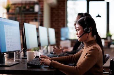A picture of a customer care executive diligently working on her computer.