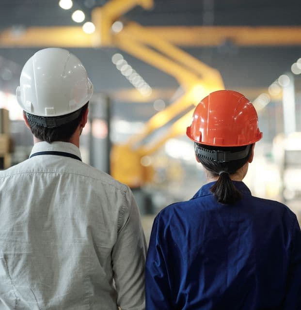 A back picture of three architects standing in a workstation.